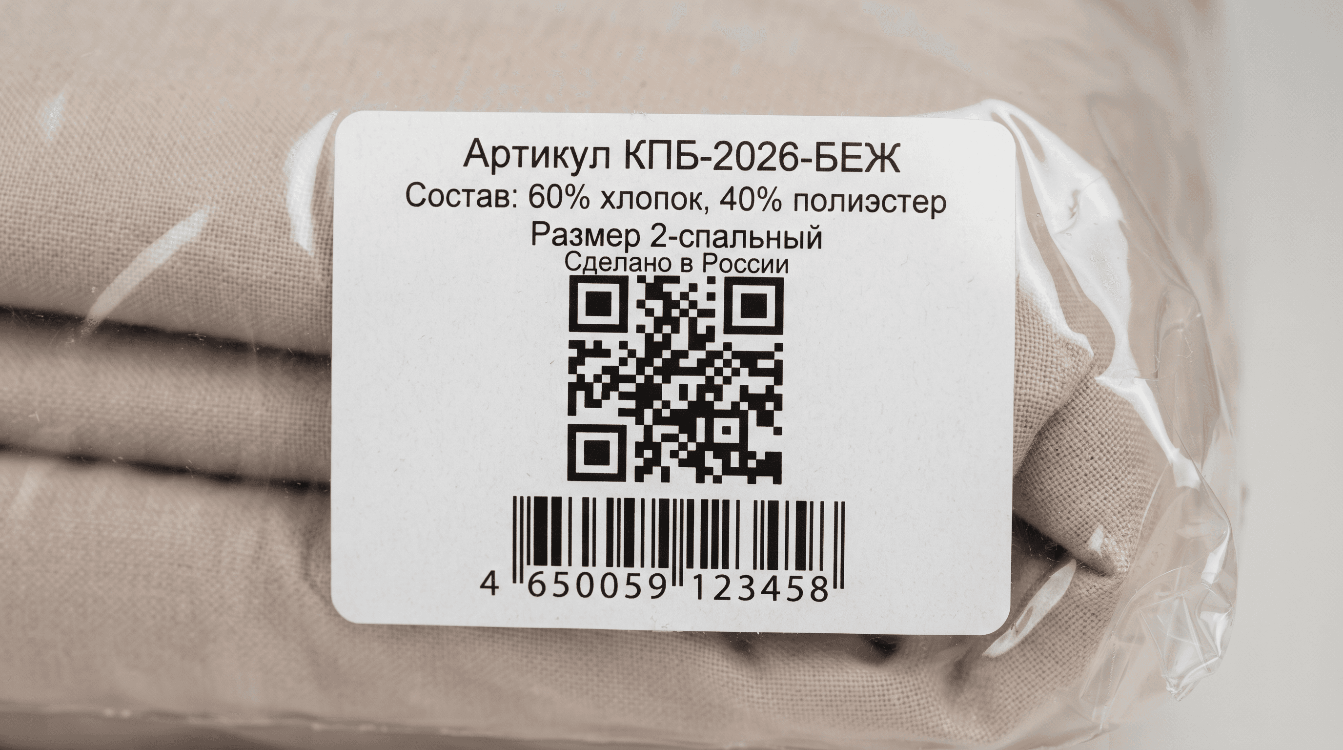 Белая самоклеящаяся этикетка на прозрачной упаковке комплекта постельного белья: код Data Matrix, артикул, состав ткани и размер на русском языке