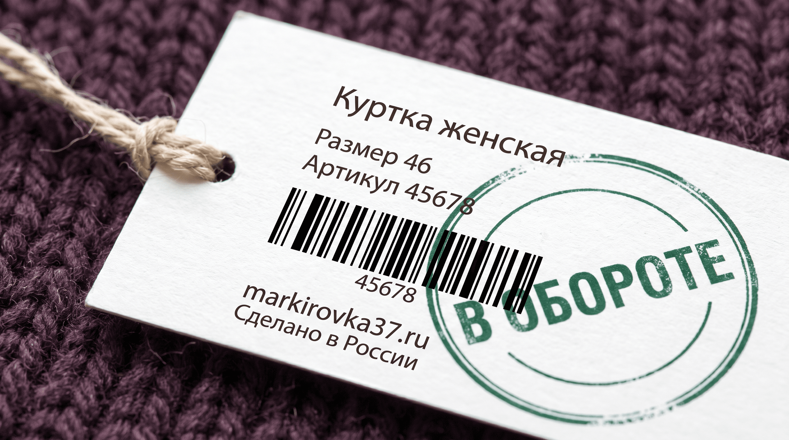 Крупный план картонной навесной бирки на женской куртке со штрихкодом, артикулом и зелёным круглым штампом «В обороте» - визуальная метафора статуса кода в системе Честный знак